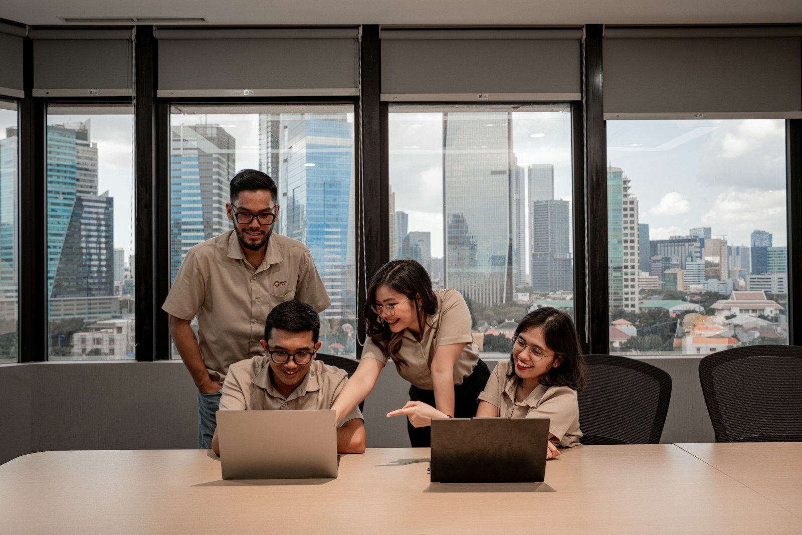 Diverse enterprise technology team collaborating around laptops in a modern office — strategic resourcing across SAP, cloud, AI engineering, data, DevOps, and cybersecurity